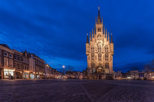 Bezoekers lopen langs verlichte ijssculpturen op het Nederlands IJsbeelden Festival tijdens een sfeervol winteruitje