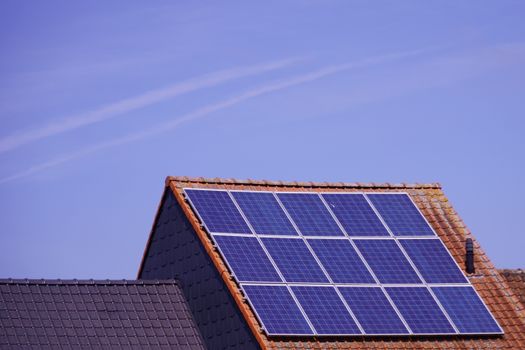 Huiseigenaar bekijkt thuisbatterij naast omvormer en zonnepanelen in 2026