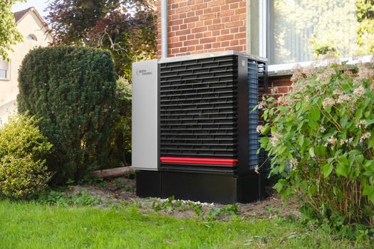 Buitenunit van een hybride warmtepomp naast een Nederlandse woning in 2026