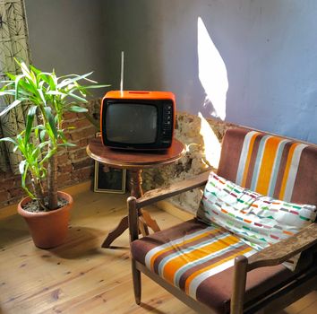 Woonkamer met jaren 70 interieur, warme aardetinten, ronde bank en vintage verlichting