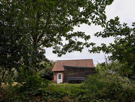 Tiny house in een achtertuin met moderne afwerking en kleine warmtepomp naast de woning